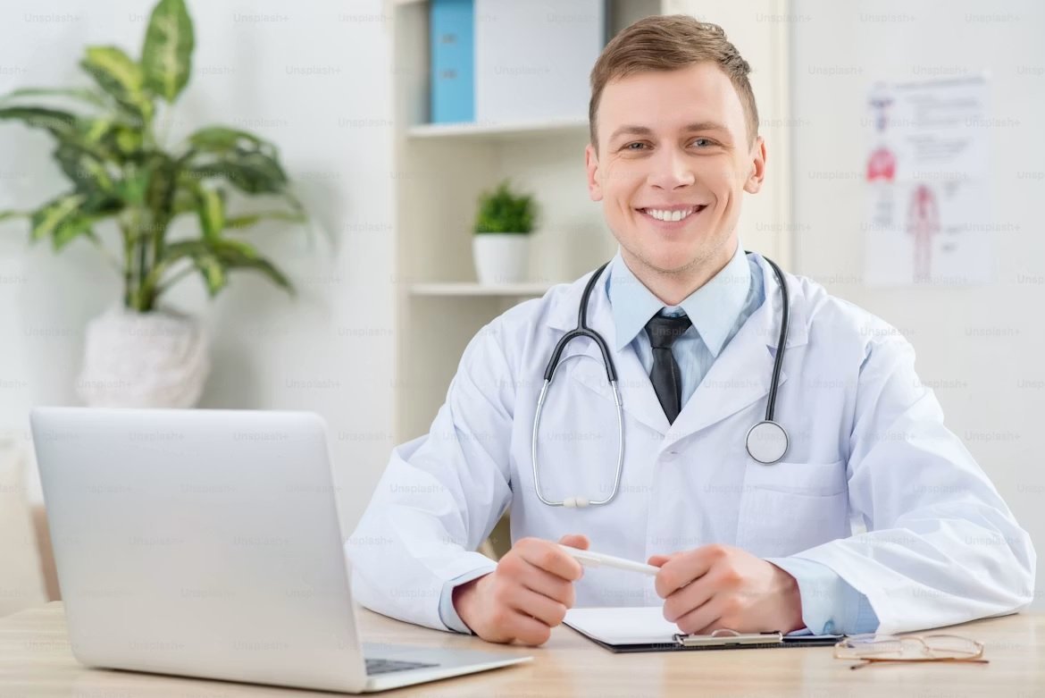 Médico em consultório trabalhando com laptop